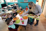 Amy McCoy serves lunch to preschoolers at her Forever Young Daycare facility, Monday, Oct. 25, 2021, in Mountlake Terrace, Wash. Child care centers once operated under the promise that it would always be there when parents have to work. Now, each teacher resignation, coronavirus exposure, and day care center closure reveals an industry on the brink, with wide-reaching implications for an entire economy's workforce. (AP Photo/Elaine Thompson)