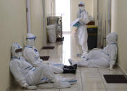 Dr. Irman Pahlepi, front, with team members rest after treating a COVID-19 patient at the Dr. Suyoto General Hospital in Jakarta, Indonesia, on July 29, 2021. Pahlepi is back at work in the hospital, immediately resuming his duties treating COVID-19 patients after recovering from an infection himself, for the second time. With numbers of infections in Indonesia skyrocketing and deaths steadily climbing, health care workers are being depleted as the virus spares nobody, Pahlepi felt he had no option but to jump right back in. (AP Photo/Tatan Syuflana)