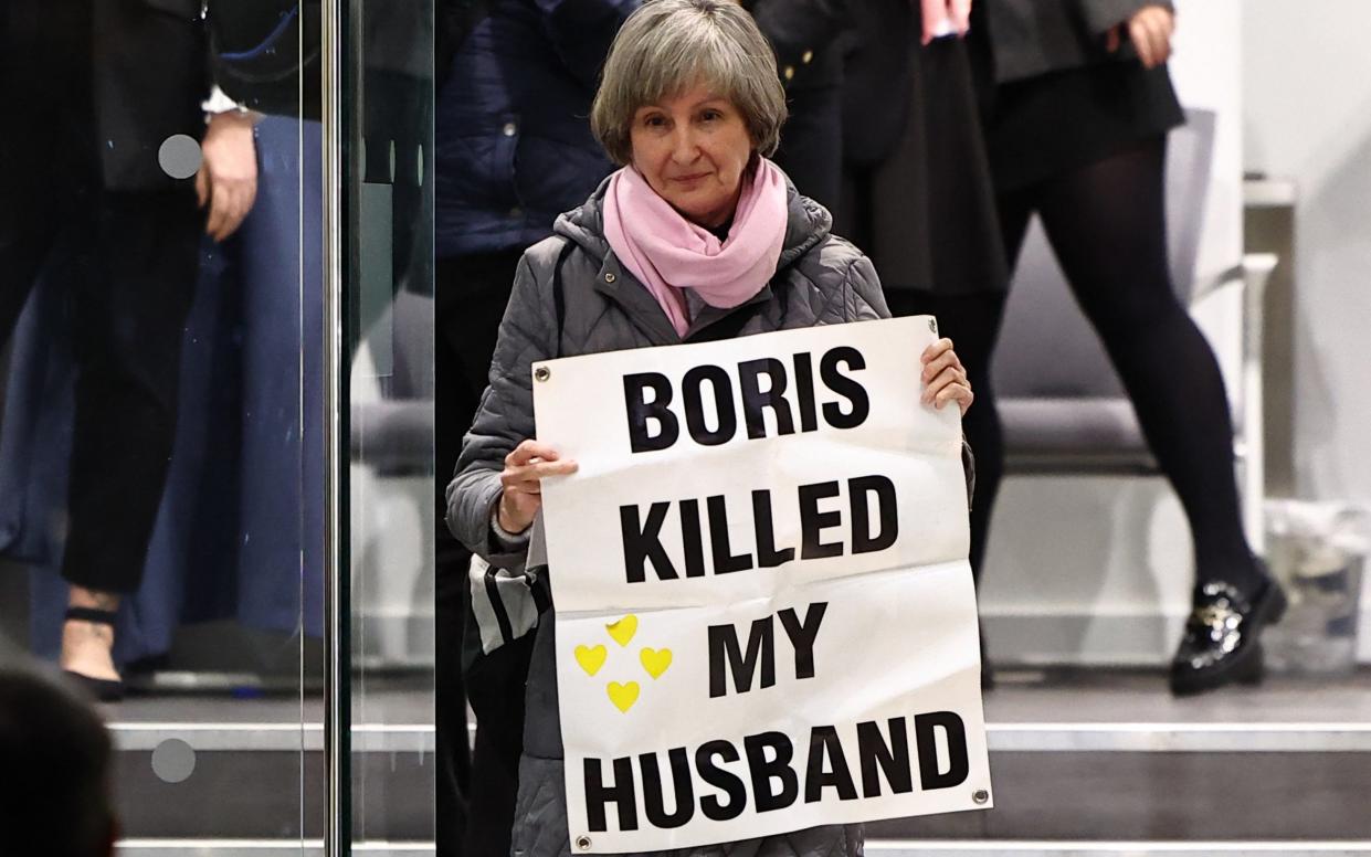 A demonstrator outside the Covid Inquiry, where Boris Johnson was giving evidence