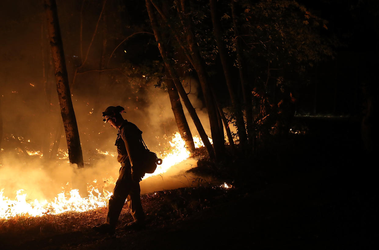 Cal Fire firefighter Brandon Tolp uses a drip torch during a firing operation while battling the Tubbs Fire on Oct. 12, 2017, near Calistoga, California. (Photo: Justin Sullivan via Getty Images)