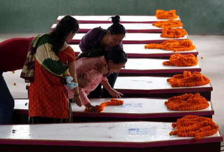 Family members cry near coffins containing the bodies of Nepali nationals, who were killed when a suicide bomber struck a minibus in Kabul, lined up after being flown from Afghanistan at Tribhuvan International Airport in Kathmandu, Nepal June 22, 2016. REUTERS/Navesh Chitrakar