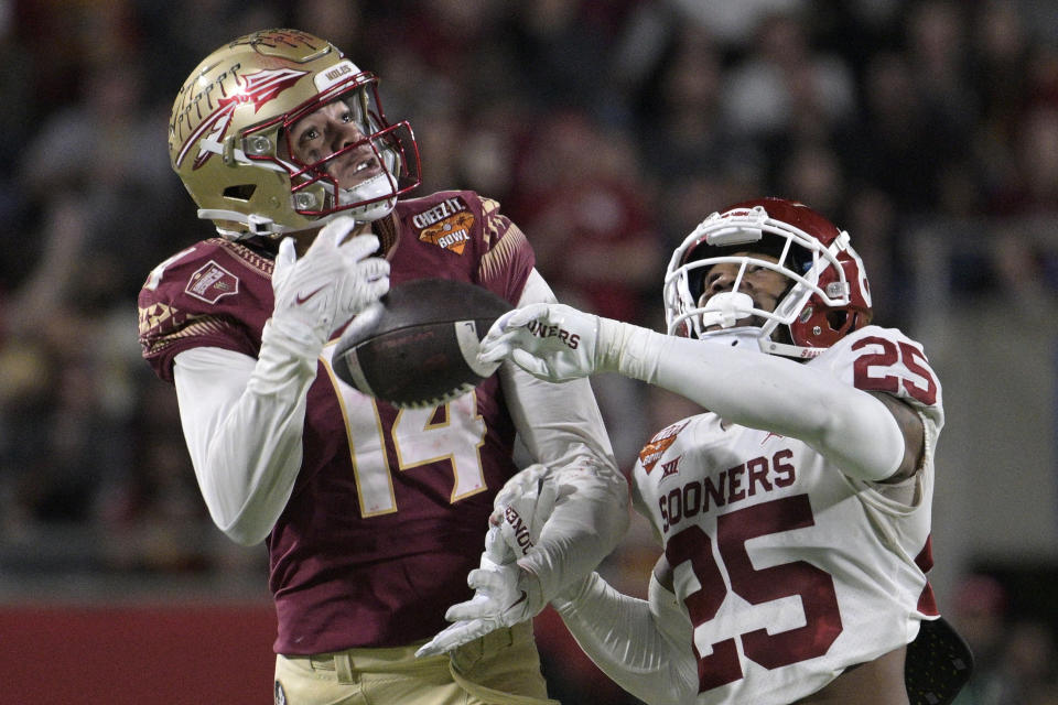 FILE - Florida State wide receiver Johnny Wilson (14) makes a reception while defended by Oklahoma defensive back Justin Broiles (25) during the second half of the Cheez-It Bowl NCAA college football game, Thursday, Dec. 29, 2022, in Orlando, Fla. Florida State opens their season at home against LSU on Sept. 3. (AP Photo/Phelan M. Ebenhack, File)