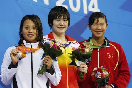 Gold medallist Ye Shiwen of China (C) poses with silver medallist Sakiko Shimizu of Japan (L) and bronze medallist Thi Anh Vien Nguyen of Vietnam on the podium at the women's 400m individual medley final award ceremony at the Munhak Park Tae-hwan Aquatics Center during the 17th Asian Games in Incheon September 23, 2014. REUTERS/Tim Wimborne