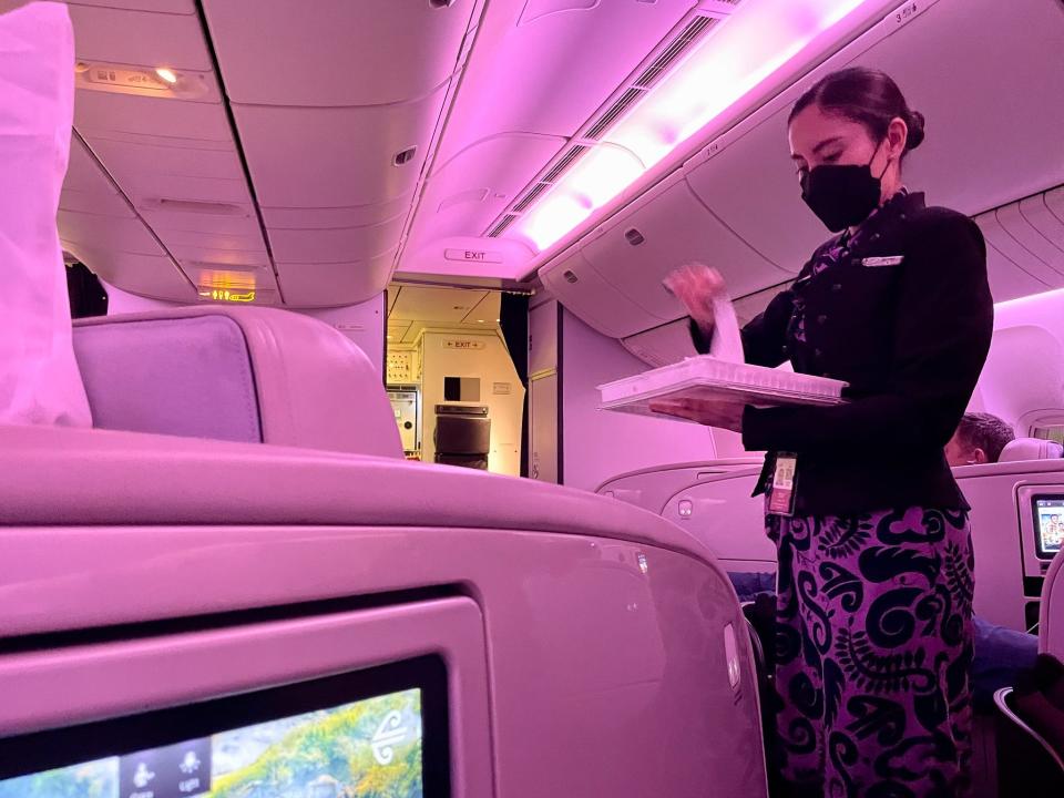 Eine Flugbegleiterin der Air New Zealand verteilte warme Handtücher an die Passagiere der Business Class.