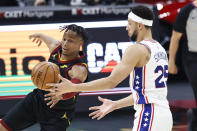 Cleveland Cavaliers' Isaac Okoro (35) battles Philadelphia 76ers' Ben Simmons (25) for a rebound in the first half of an NBA basketball game, Thursday, April 1, 2021, in Cleveland. (AP Photo/Ron Schwane)