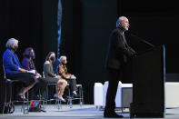 In this Monday, Oct. 18, 2021 photo, Rabbi Hazzan Jeffrey Myers, right, gives the invocation on the first day of the Eradicate Hate Global Summit in Pittsburgh. Rabbi Myers is a survivor of the Oct. 27, 2018 mass shooting at the Tree of Life synagogue. Seated from left are Kathleen Blee, Lorrie Cranor, Michele Rosenthal and Laura Ellsworth, who also gave opening remarks at the summit. (AP Photo/Rebecca Droke)