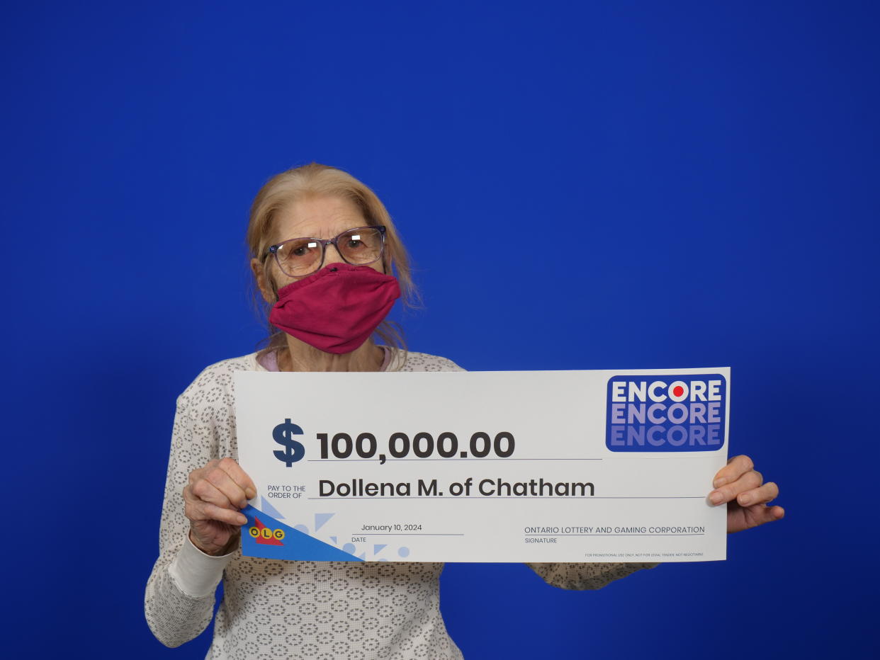 Woman holding a $100,000 lottery cheque after winning through Encore. 