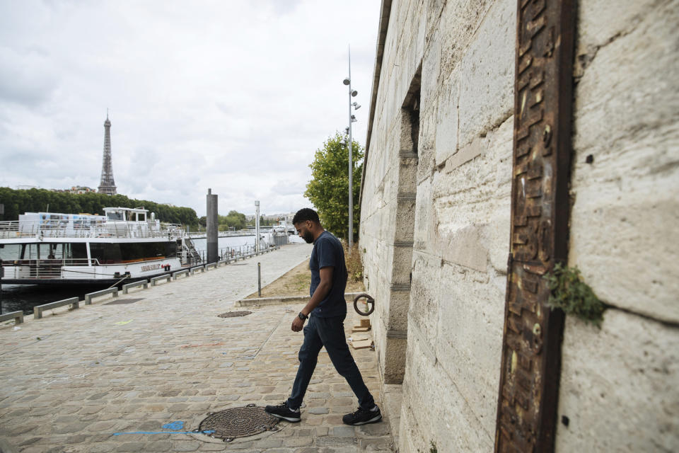 A worker leaves part of Fraicheur de Paris' underground cooling system near the Seine in Paris, Tuesday, July 26, 2022. When the Seine's water is cold enough, a machine captures it and uses it to chill the system's water. (AP Photo/Lewis Joly)