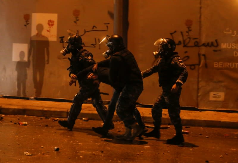 Riot police restrain a protestor during a protest against a ruling elite accused of steering Lebanon towards economic crisis in Beirut