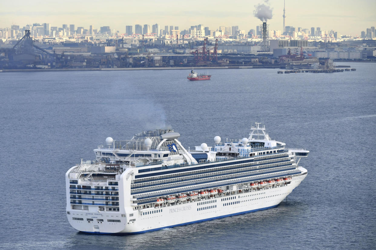 A cruise ship Diamond Princess anchor off the Yokohama Port upon arrival in Yokohama, near Tokyo Tuesday, Feb. 4, 2020. A person who was a passenger on the Japanese-operated cruise ship has tested positive for a new virus after leaving the ship in Hong Kong on Jan. 25. The ship returned to Yokohama carrying 3,000 passengers and crew members after making port calls in Vietnam, Taiwan and Okinawa. A team of quarantine officials and medical staff boarded the ship on Monday night and began medical checks of everyone on board, a health ministry official said on condition of anonymity, citing department rules. (Kyodo News via AP)