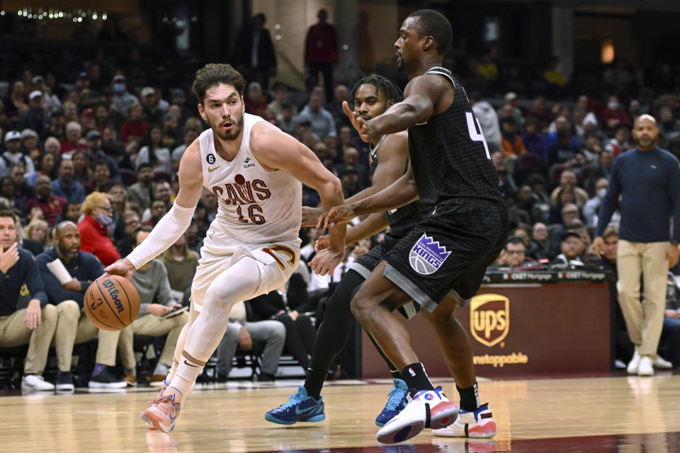 Cleveland Cavaliers forward Cedi Osman, left, drives against Sacramento Kings forward Harrison Barnes during the first half of an NBA basketball game Friday, Dec. 9, 2022, in Cleveland. (AP Photo/Nick Cammett)