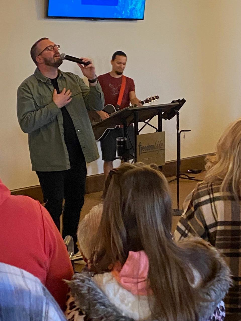 Matthew Holladay, lead pastor at Winchester's Freedom Life Church, leads his congregation in a song at a Sunday morning service held at the Town Square Community Centre. Thursday night's tornado demolished Freedom Life Church's longtime home along Greenville Pike.