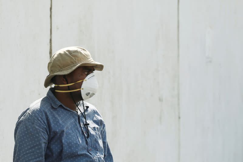 FILE PHOTO: A man wearing a face mask waits to see a relative who is admitted after being affected from a suspected gas leak, at a hospital premises in Karachi