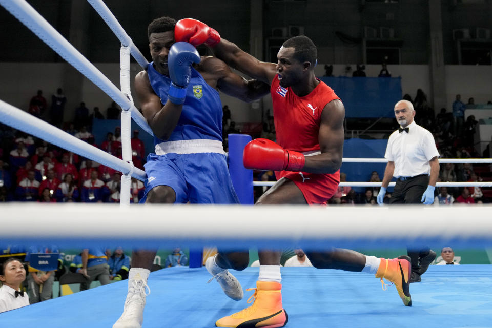 ARCHIVO - El cubano Julio La Cruz (derecha) conecta un golpe al brasileño Keno Machado en la final de los 92 kilogramos del boxeo de los Juegos Panamericanos, el 27 de octubre de 2023, en Santiago, Chile. (AP Foto/Martín Mejía)