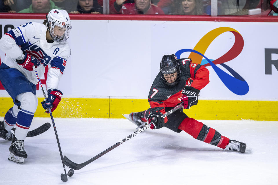 Canada's Laura Stacey (7) knocks the puck away from United States' Megan Keller (5) during second-period Rivalry Series women's hockey game action in Regina, Saskatchewan, Friday, Feb. 9, 2024. (Liam Richards/The Canadian Press via AP)