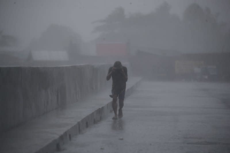 A villager braves strong wind as he traverses a road in Bacoor city, Cavite, Philippines, on October 29. The National Disaster Risk Reduction and Management Council said 45 people died from the effects of Typhoon Nalgae in October. File Photo by Francis R. Malasig/EPA-EFE