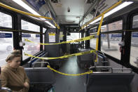 The front of a New York City bus is cordoned off to keep passengers and the driver separated, Monday, March 23, 2020. Gov. Andrew Cuomo has ordered most New Yorkers to stay home from work to slow the coronavirus pandemic. (AP Photo/Mark Lennihan)