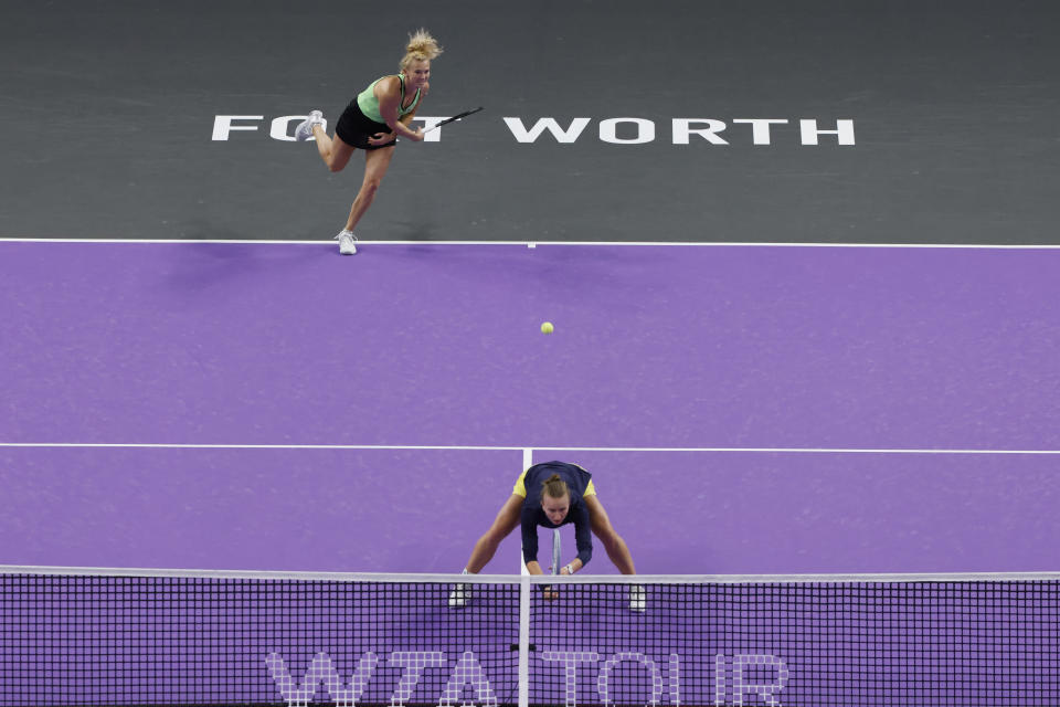 Katerina Siniakova, top, of the Czech Republic, hits over doubles partner Barbora Krejcikova, bottom, also of the Czech Republic, in the final of the WTA Finals tennis tournament against Veronika Kudermetova, of Russia, and Elise Mertens, of Belgium, in Fort Worth, Texas, Monday, Nov. 7, 2022. (AP Photo/Ron Jenkins)