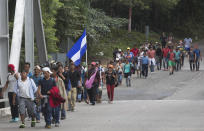 Honduran migrants walk toward the U.S. as they make their way through Chiquimula, Guatemala, Tuesday, Oct. 16, 2018. U.S. President Donald Trump threatened on Tuesday to cut aid to Honduras if it doesn't stop the impromptu caravan of migrants, but it remains unclear if governments in the region can summon the political will to physically halt the determined border-crossers. (AP Photo/Moises Castillo)