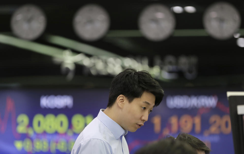 A currency trader watches the computer monitors near the screens showing the Korea Composite Stock Price Index (KOSPI), left, and the foreign exchange rate between U.S. dollar and South Korean won at the foreign exchange dealing room in Seoul, South Korea, Wednesday, May 15, 2019. Asian stocks followed Wall Street higher on Wednesday after President Donald Trump downplayed his escalating tariff war with Beijing and said a settlement is possible.(AP Photo/Lee Jin-man)