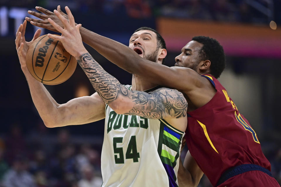 Milwaukee Bucks forward Sandro Mamukelashvili attempts to catch a pass while being defended by Cleveland Cavaliers center Evan Mobley, right, in the first half of an NBA basketball game, Sunday, April 10, 2022, in Cleveland. (AP Photo/David Dermer)