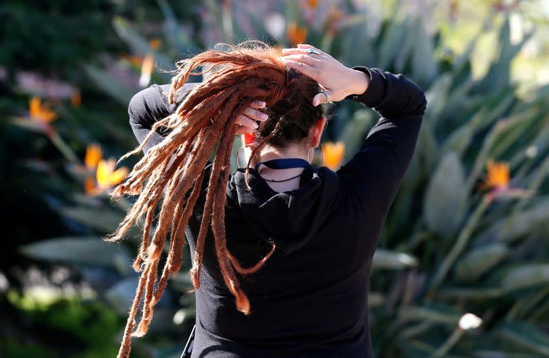 FILE PHOTO: A woman arranges her dreadlocked hair in a public square in Valparaiso