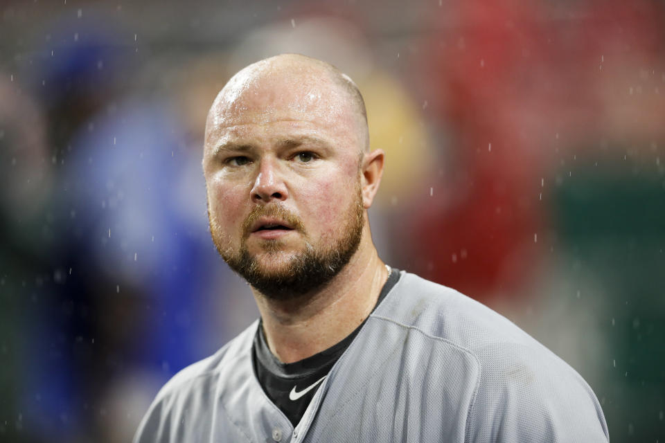 Jon Lester stands in the dugout.