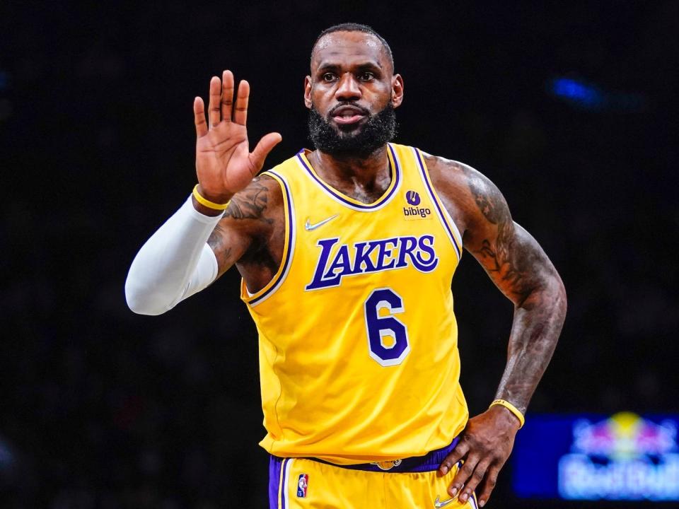 LeBron James holds up his hand during a game in 2022.