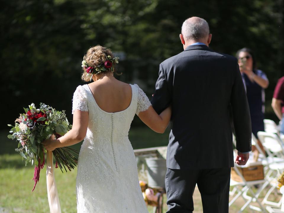 A bride walks down the aisle with her father