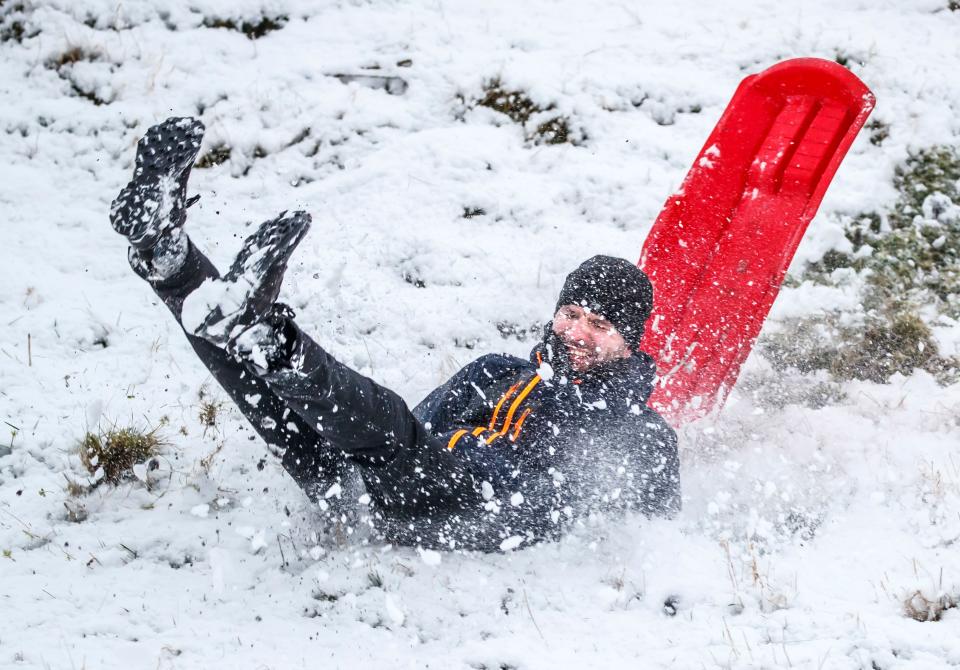 <p>A man falls off a sledge near Winnats Pass in Derbyshire.</p>PA