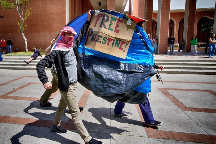 University of Southern California protesters carry a tent around Alumni Park on the University of Southern California to keep security from removing it during a pro-Palestinian occupation on Wednesday, April 24, 2024, in Los Angeles. (AP Photo/Richard Vogel)