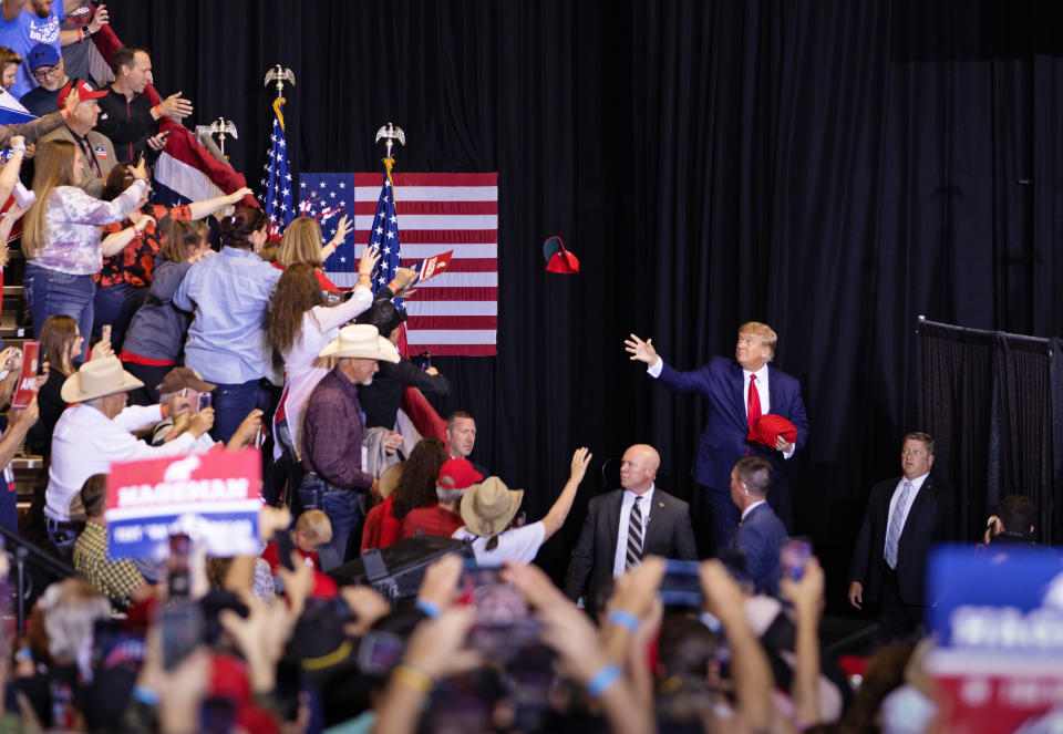 Former President Donald Trump tosses red MAGA hats to the crowd during a rally May 28, 2022 at the Ford Event Center in Casper, Wyo. (David Stubbs for NBC News)