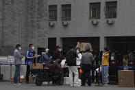 Couriers pass over their deliveries at one of the entrance to the main campus of Peking University on Tuesday, May 17, 2022, in Beijing. Administrators at the elite Beijing university have backed down from plans to further tighten pandemic restrictions on students as part of China’s “zero-COVID” strategy after a weekend protest at the school, according to students Tuesday. (AP Photo/Ng Han Guan)