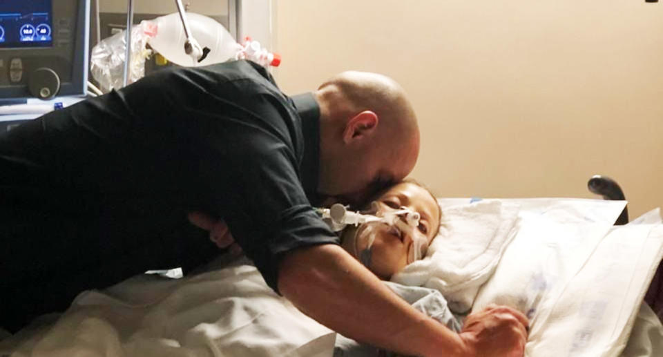 Zach Kincaid kisses his wife Krystil as she remains on life support after the crash.