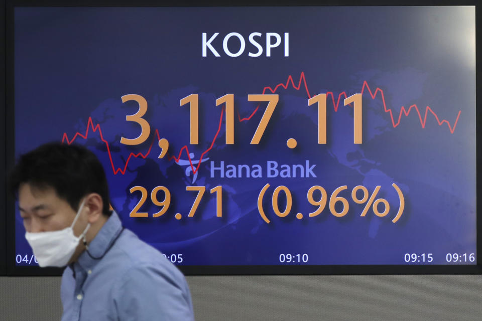 A currency trader walks near the screen showing the Korea Composite Stock Price Index (KOSPI) at the foreign exchange dealing room of the KEB Hana Bank headquarters in Seoul, South Korea, Friday, April 2, 2021. Asian shares were higher Friday after a broad rally pushed the S&P 500 past 4,000 points for the first time. (AP Photo/Lee Jin-man)