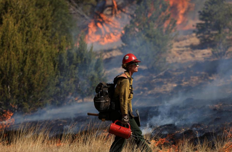 A firefighter conducts a prescribed burn to combat the Hermits Peak and Calf Canyon wildfires, near Las Vegas, New Mexico, U.S. May 4, 2022. REUTERS/Kevin Mohatt - RC2G0U9PXKD3