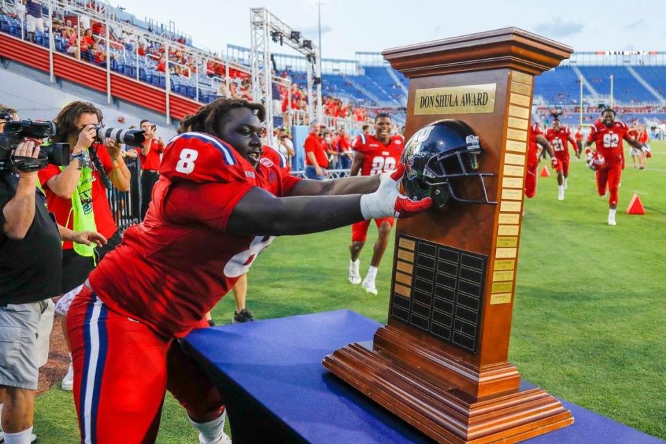 Florida Atlantic Owls defensive lineman Evan Anderson (8) rips-off the Florida International University helmet from the Don Shula Award Trophy after winning the game at FAU Stadium in Boca Raton, Florida on Saturday, October 2, 2021. SAM NAVARRO/Special for the Miami Herald