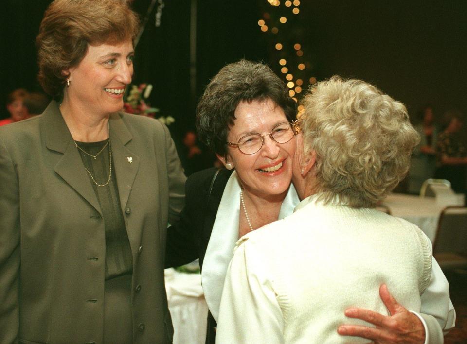 Mary Jo Wynn, center, receives a congratulatory hug from friend Bee Payne-Stewart while Linda Dollar, left, looks on at Wynn's retirement reception party at University Plaza Convention Center in 1998.