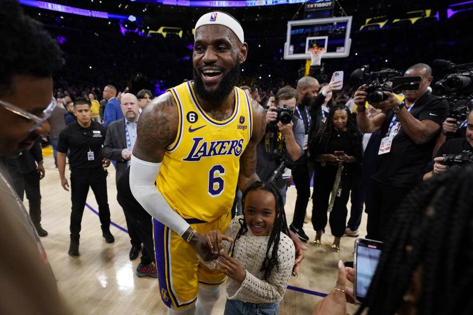 Los Angeles Lakers forward LeBron James celebrates with his daughter Zhuri after passing Kareem Abdul-Jabbar to become the NBA's all-time leading scorer during the second half of an NBA basketball game against the Oklahoma City Thunder Tuesday, Feb. 7, 2023, in Los Angeles.(AP Photo/Ashley Landis)