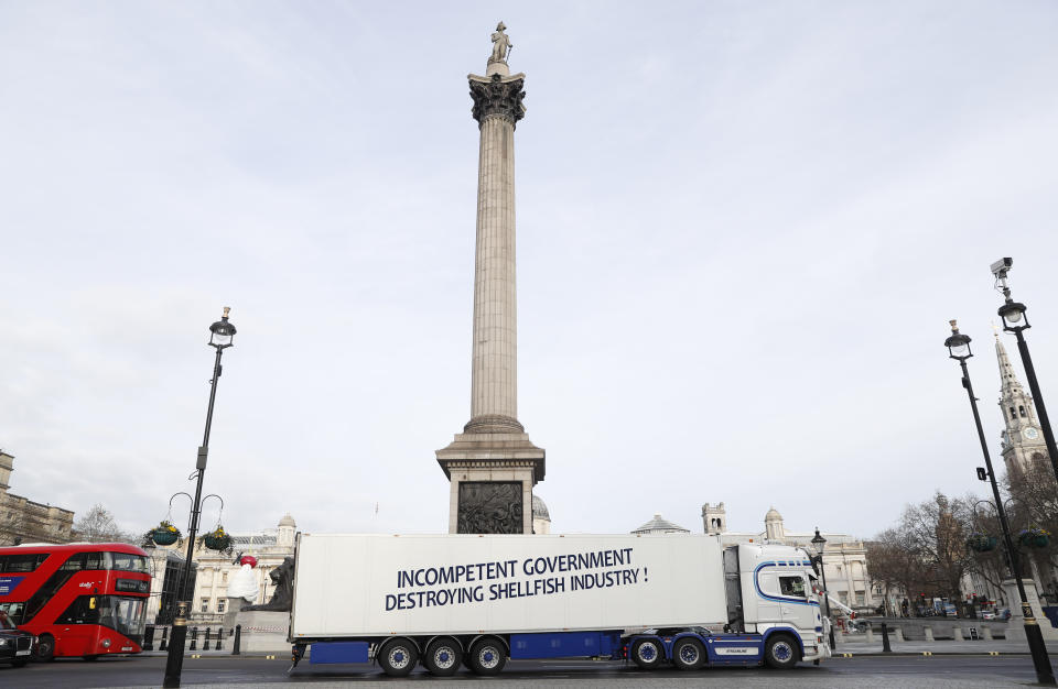 A shellfish export truck with a protest sign written across the trailer 'Incompetent Government Destroying Shellfish Industry" drives around Trafalgar Square in London, Monday, Jan. 18, 2021, during a demonstration by British Shellfish exporters to protest Brexit-related red tape they claim is suffocating their business. (AP Photo/Alastair Grant)