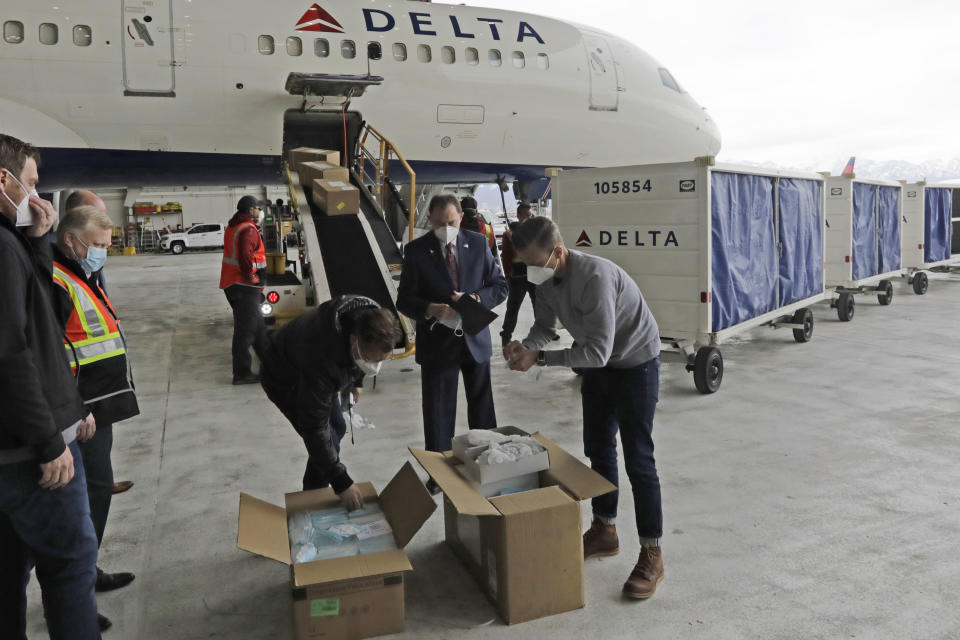 Utah Gov. Gary Herbert, center, looks on as a plane filled with personal protective equipment is unloaded at the Delta Hanger Wednesday, April 15, 2020, at the Salt Lake International Airport. The first of several planes filled with personal protective equipment touched down in Utah, delivering masks and eye protection for health care workers throughout the state. "We are in a wartime environment. (AP Photo/Rick Bowmer)