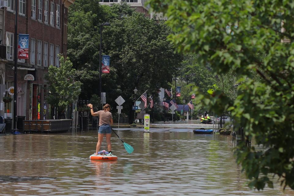 A person rows a paddle board in a flooded area in Montpelier, Vermont on Tuesday, July 11, 2023 (REUTERS/Brian Snyder)