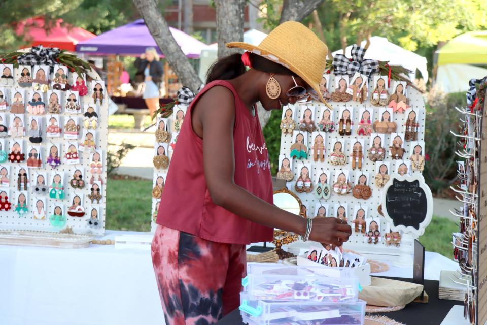 Prossy Lemke sets up her booth for the first Center City Community Market of the 2022 season downtown on Polk Street.