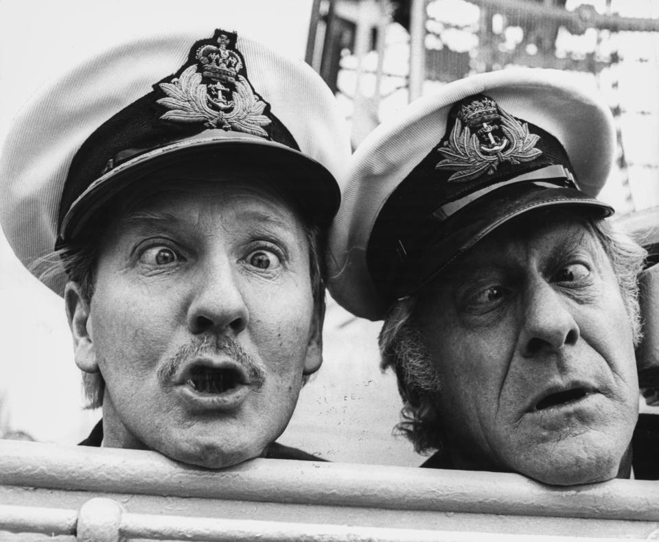 Comic actors Leslie Phillips (left) and Jon Pertwee wearing sailors hats and mugging to the camera, on board the HMS Troubridge to promote their BBC radio show &#39;Navy Lark&#39;, at Tower Bridge, London, March 26th 1969. (Photo by Ian Showell/Keystone/Getty Images)