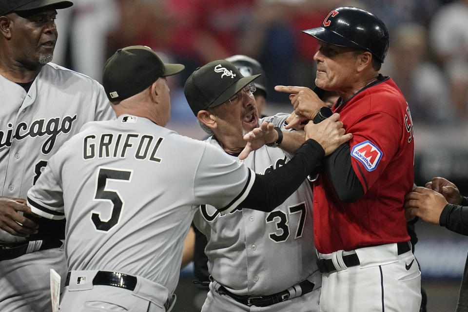 Chicago White Sox major league field coordinator Mike Tosar (37) gets between Chicago White Sox manager Pedro Grifol (5) and Cleveland Guardians third base coach Mike Sarbaugh, right, in the sixth inning of a baseball game Saturday, Aug. 5, 2023, in Cleveland. (AP Photo/Sue Ogrocki)