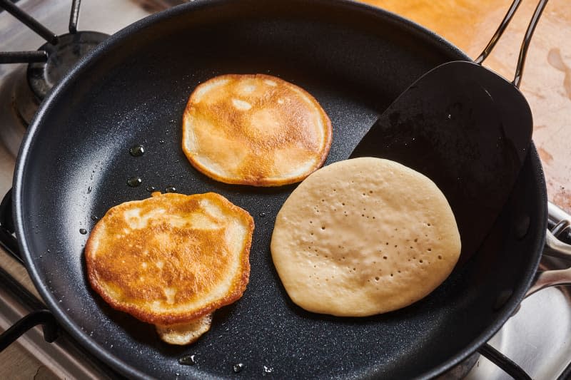 pancakes being flipped on a nonstick pan