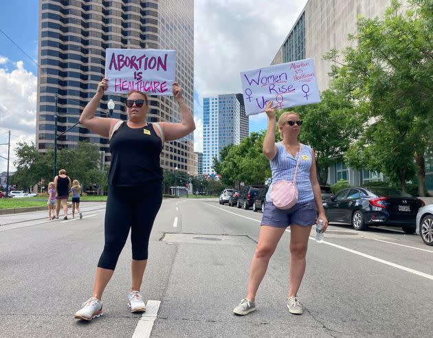 Protesters wave signs and demonstrate in support of abortion access in front of a New Orleans courthouse Friday July 8, 2022. Inside the courthouse a judge was hearing arguments on the state's trigger law designed to outlaw almost all abortions. (AP Photo/Rebecca Santana)