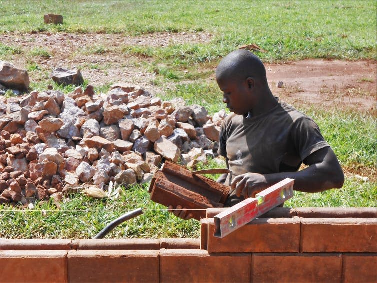 <span class="caption">The soil brick is stabilised which makes it more durable, and it does not need to be heated at extremely high temperatures like traditional bricks and cement in its manufacture. The finished product may look like these Ugandan bricks.</span> <span class="attribution"><span class="source">Haileybury Youth Trust</span>, <span class="license">Author provided</span></span>