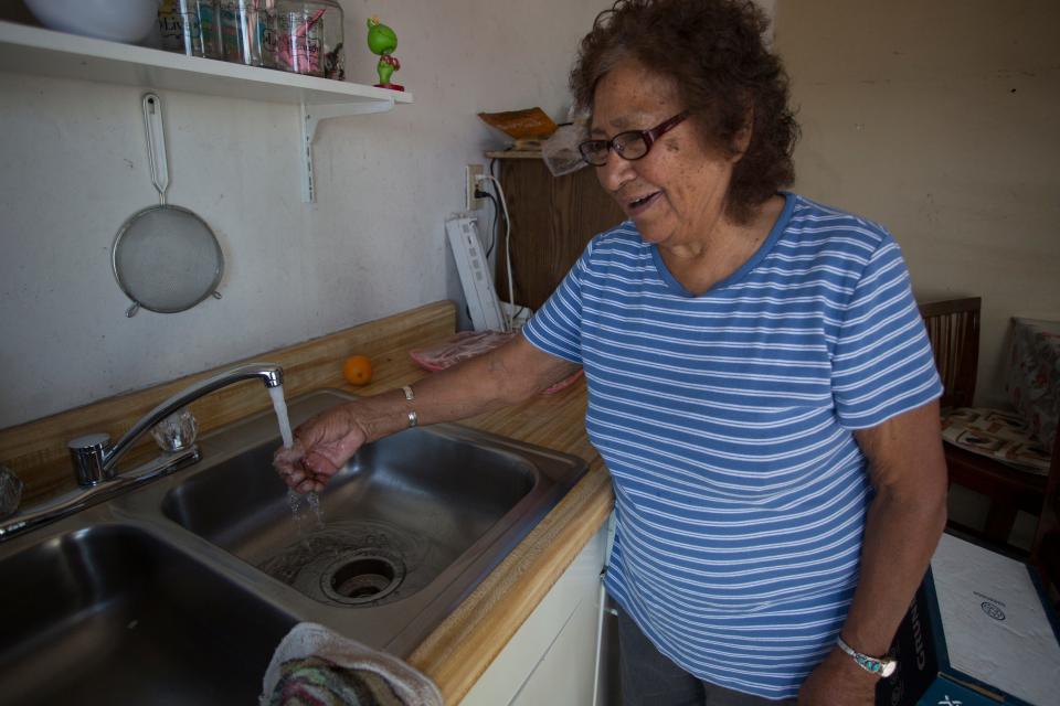A Navajo woman enjoys hot and cold running water in her home for the first time after receiving a home water/solar panel system from nonprofit DigDeep.