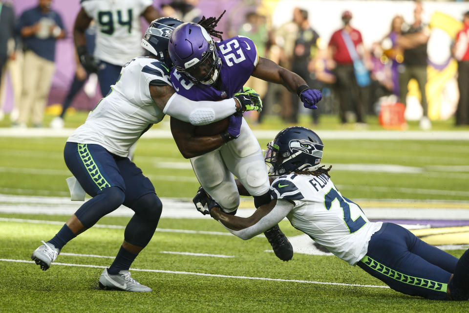 Minnesota Vikings running back Alexander Mattison (25) is tackled by Seattle Seahawks strong safety Quandre Diggs (6) and cornerback Tre Flowers (21) in the first half of an NFL football game in Minneapolis, Sunday, Sept. 26, 2021. (AP Photo/Bruce Kluckhohn)